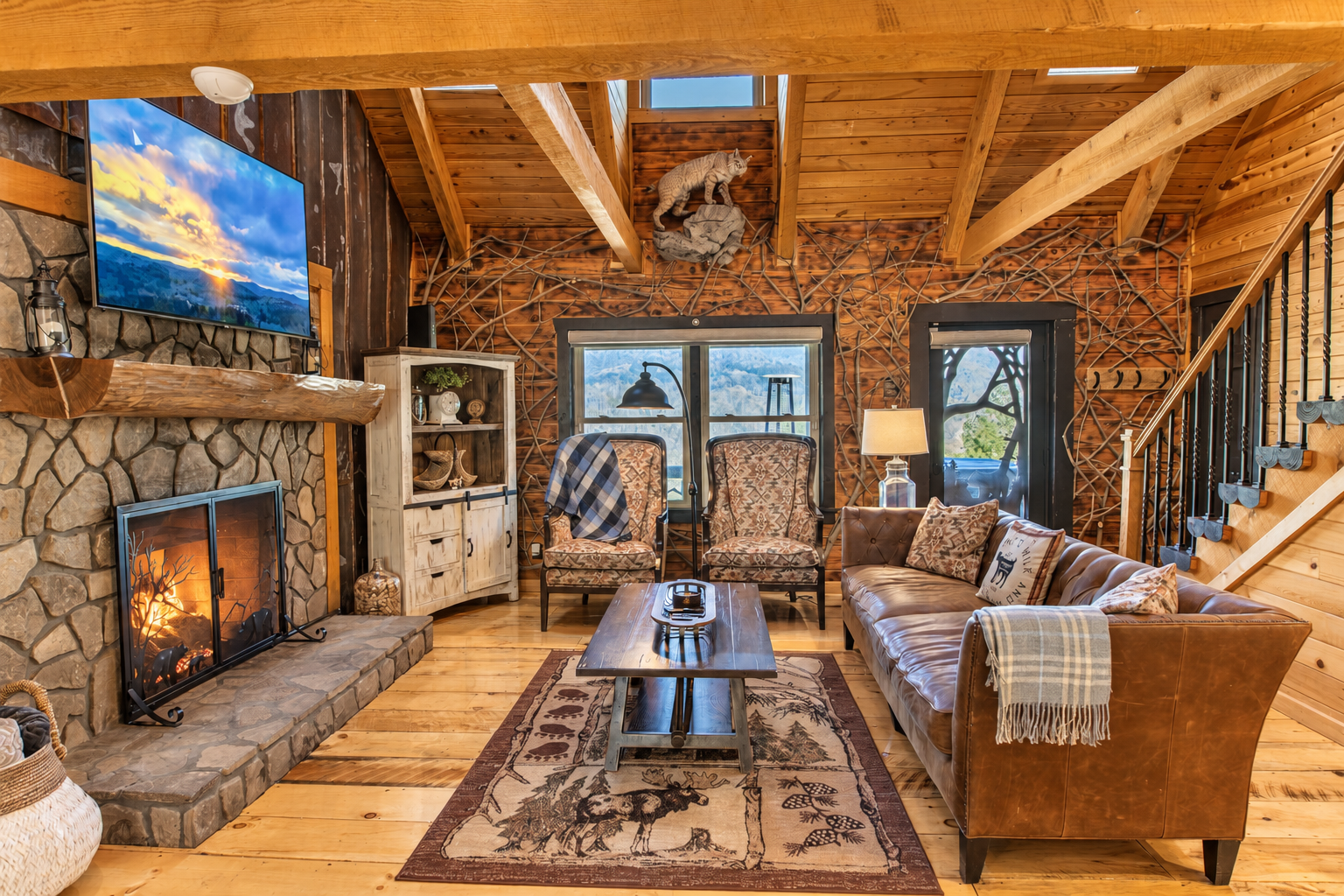 The Main Level Great Room features 17-foot high ceilings, exposed timber beams, a 65-inch flat-screen TV, panoramic views of the western Blue Ridge Mountains, and recently added wall coverings crafted from century-old tin.