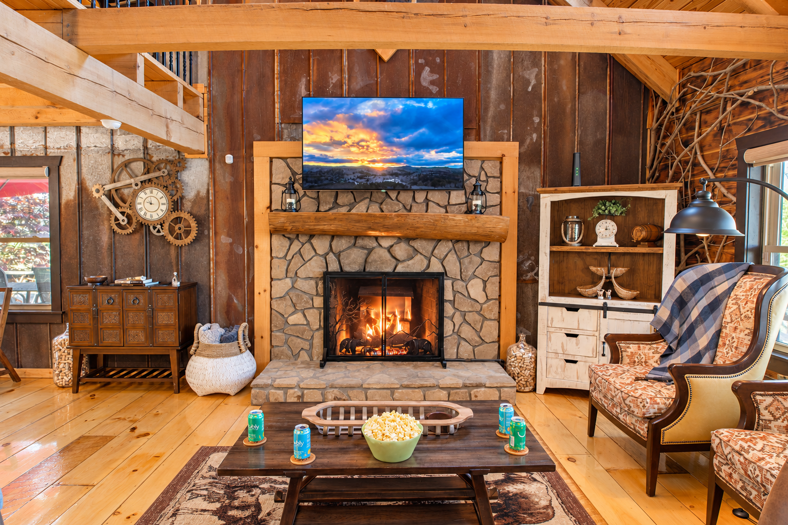Cozy rustic living room with stone fireplace, 75" TV, and warm lodge charm