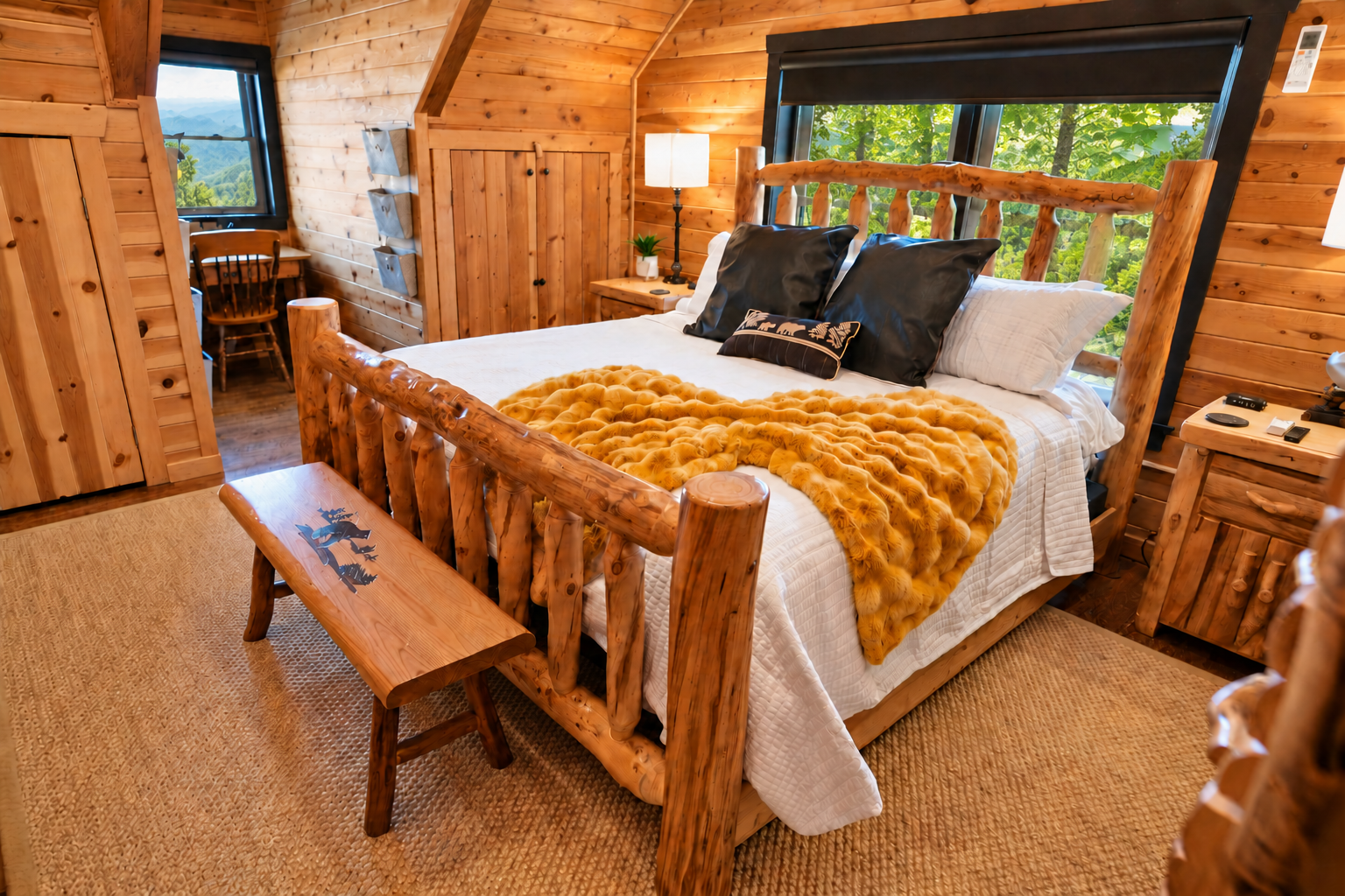 The upper-level king bedroom boasts 12-foot high ceilings with exposed timber beams, rustic log furniture, a 55-inch flat-screen TV, a gas fireplace, ensuite shower, and a dedicated workspace that offers panoramic views of the Blue Ridge Mountains.