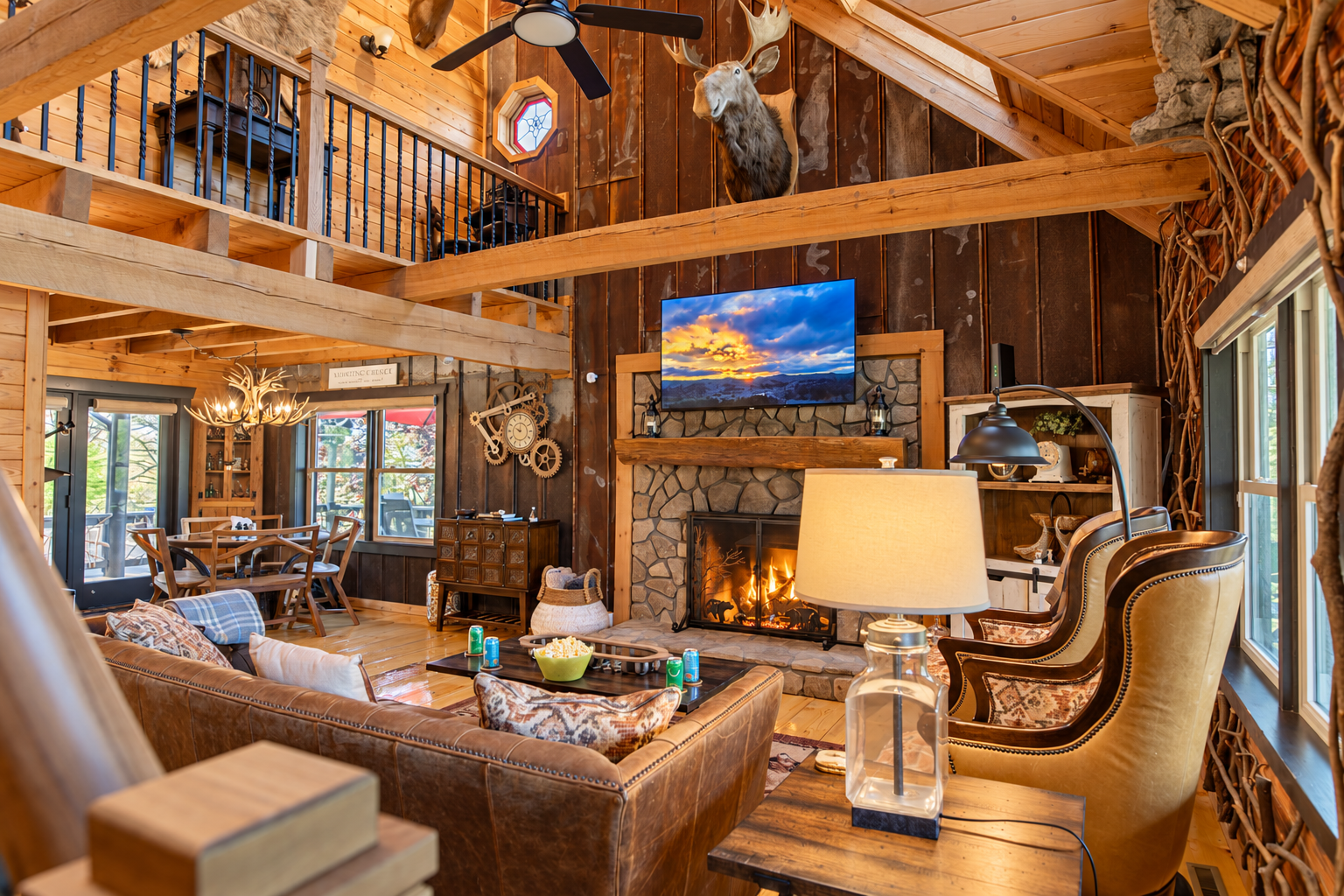 The Main Level Great Room features 17-foot high ceilings, exposed timber beams, a 65-inch flat-screen TV, panoramic views of the western Blue Ridge Mountains, and recently added wall coverings crafted from century-old tin.