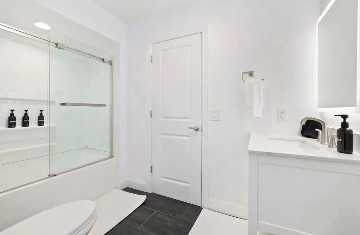 The en suite bathroom has a single sink and combination tub / shower.