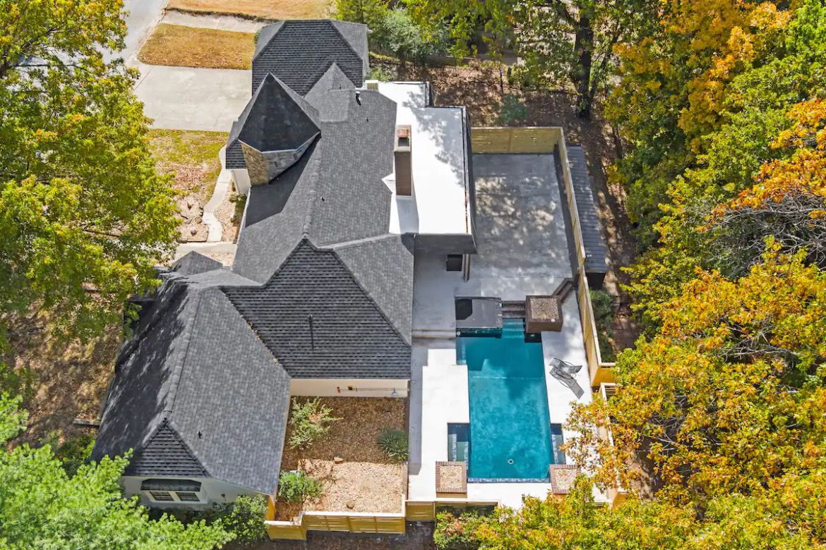 Aerial view of the home and fenced backyard with a private pool.