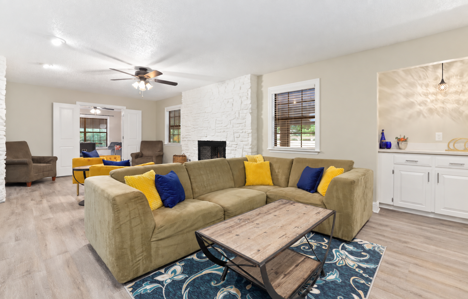 Relax in the spacious living room with a sectional, lounge chairs and a 55-inch Samsung Smart TV. The fireplace is currently non-operational.
