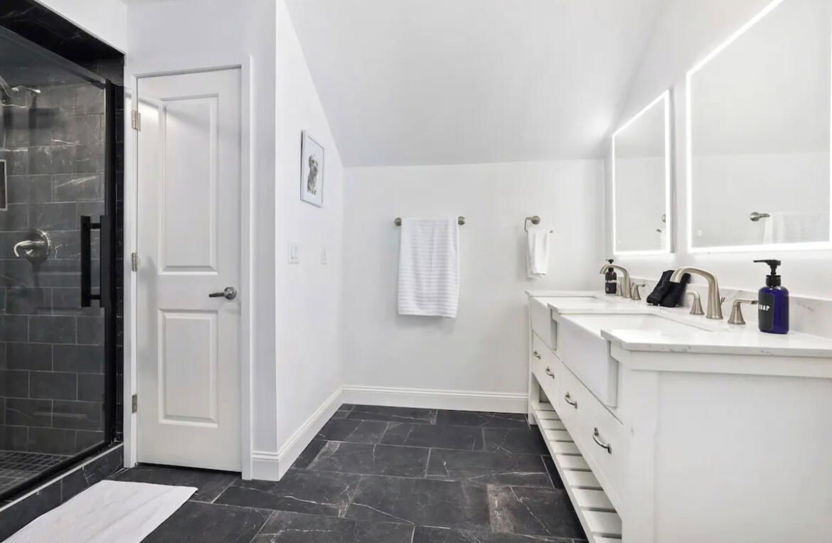 The en suite bathroom has double sinks, a large glass shower and tons of counterspace.