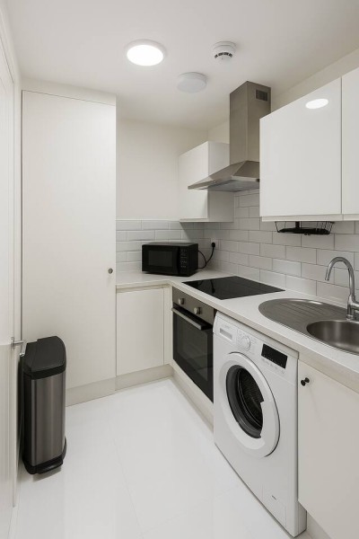 Fully equipped modern kitchen with a laundry washer, oven, and sleek cabinetry.
