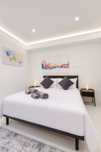 Bright, modern bedroom with cozy bedding and stylish wall art.
