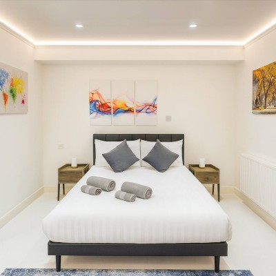 Calm, stylish bedroom with plush double bed, soft lighting and fresh towels ready.