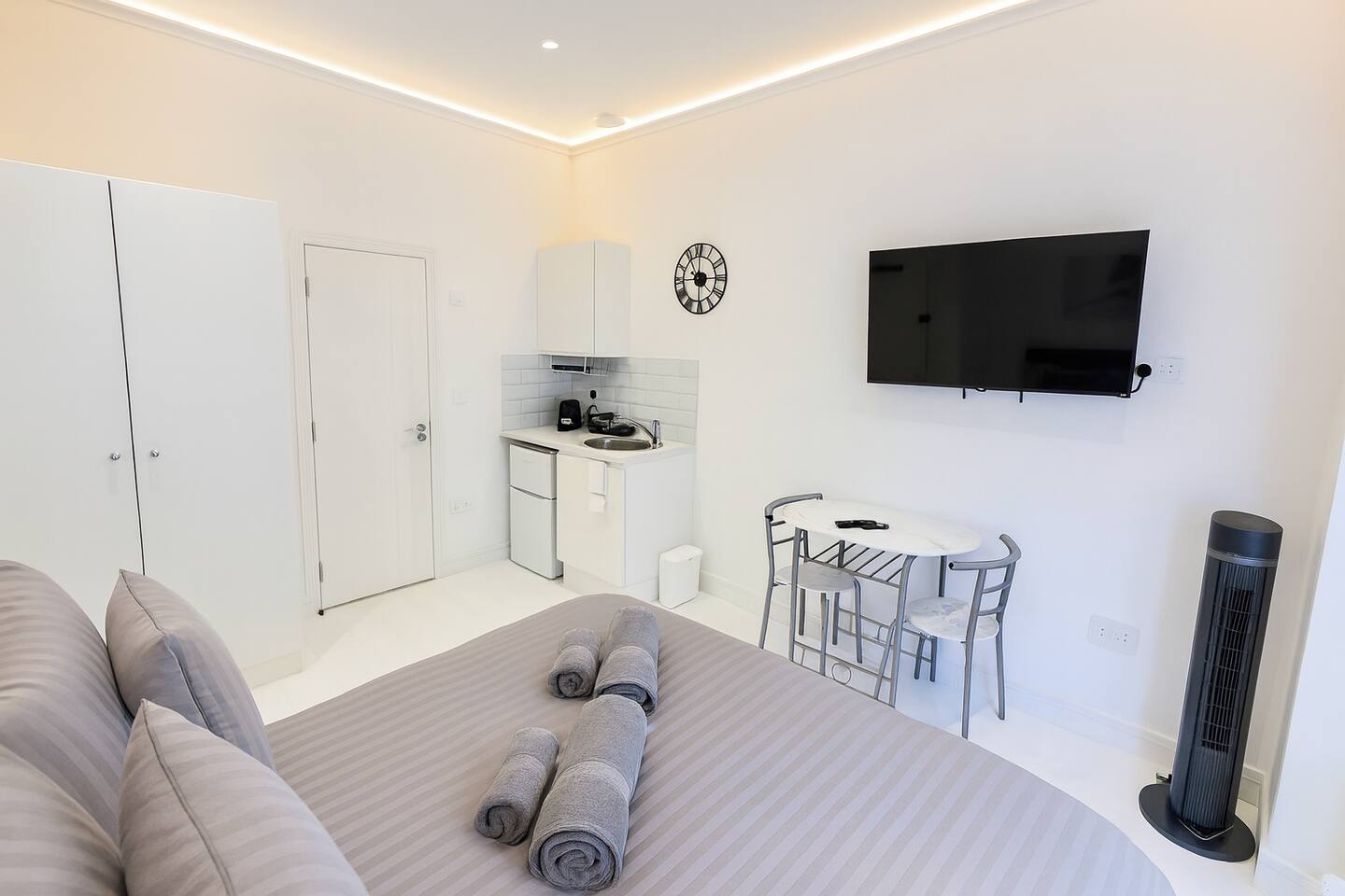 Modern studio with kitchenette, dining space, and cozy queen bed.