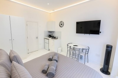 Modern studio with kitchenette, dining space, and cozy queen bed.