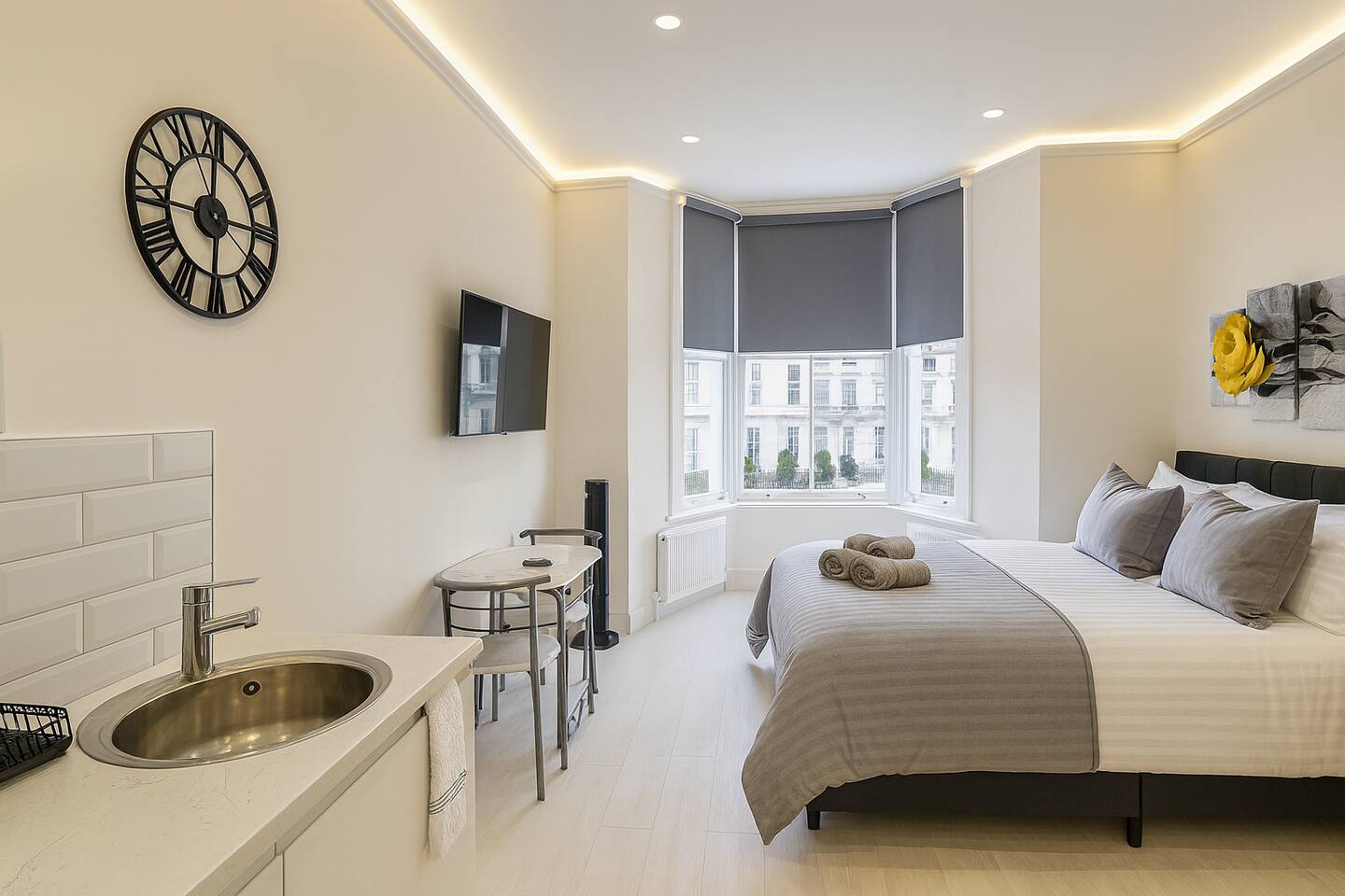 Modern studio with cozy bed, kitchenette, and stylish lighting