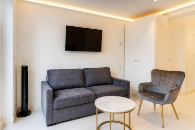 Modern living area with a plush sofa, smart TV, and chic marble coffee table.