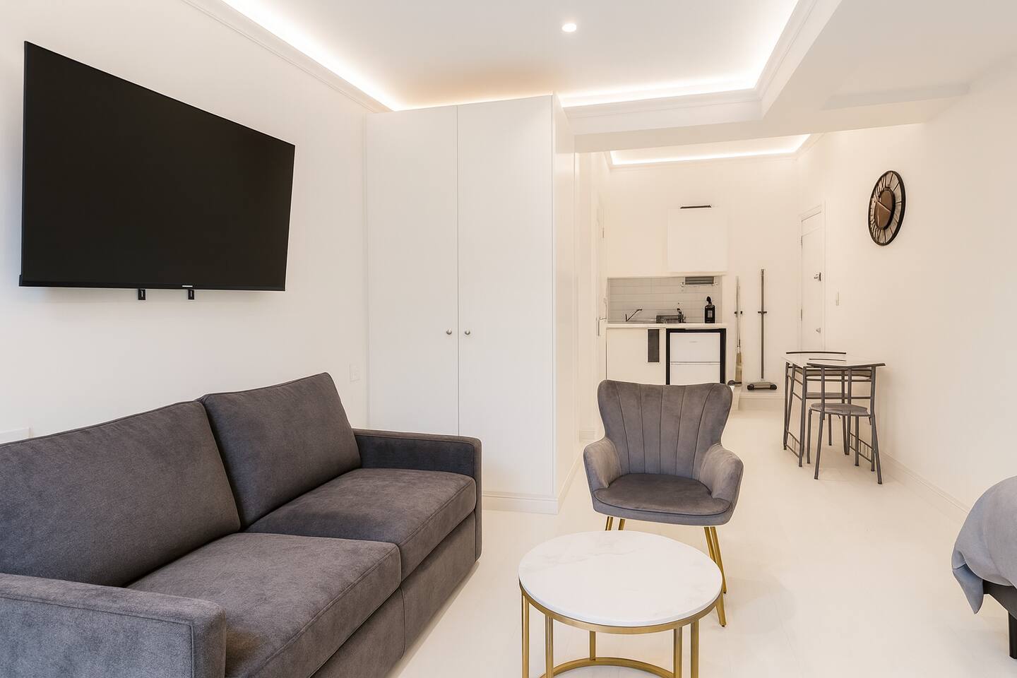 Modern living area with a plush sofa, smart TV, and chic marble coffee table.