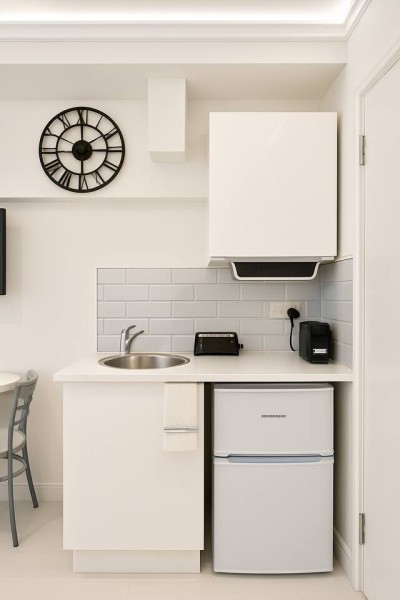 Compact kitchenette with coffee maker, toaster, and modern subway tile backsplash.