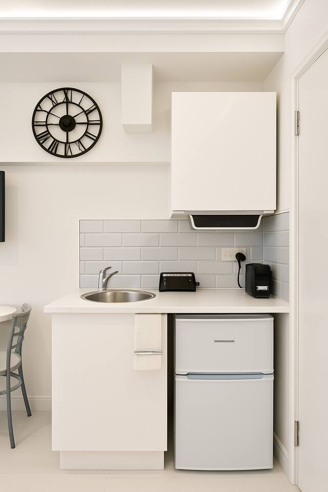 Compact kitchenette with coffee maker, toaster, and modern subway tile backsplash.