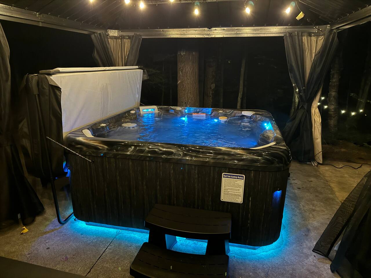 Hot tub under gazebo with string lights