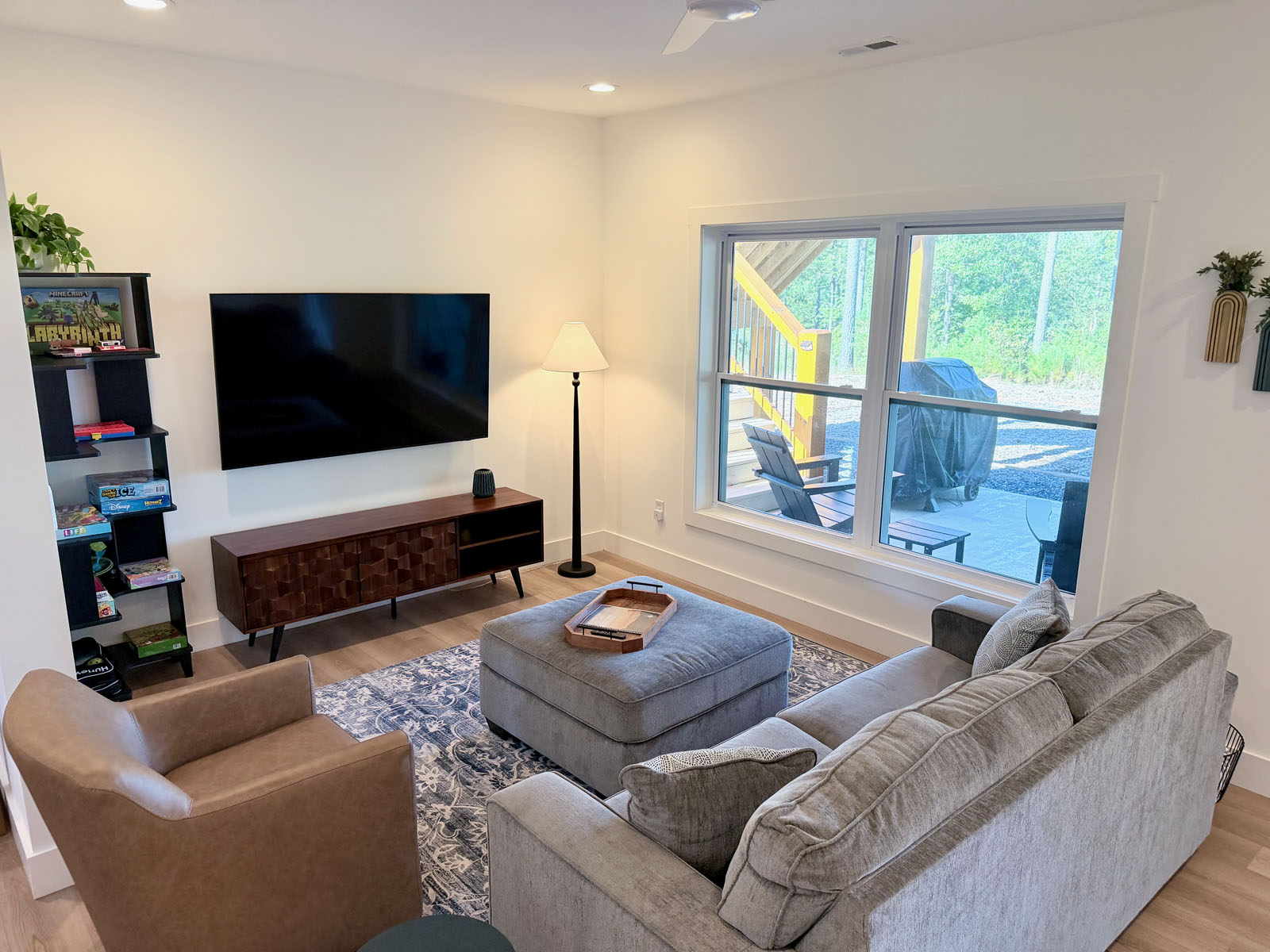 Bright modern living room with large TV and patio views