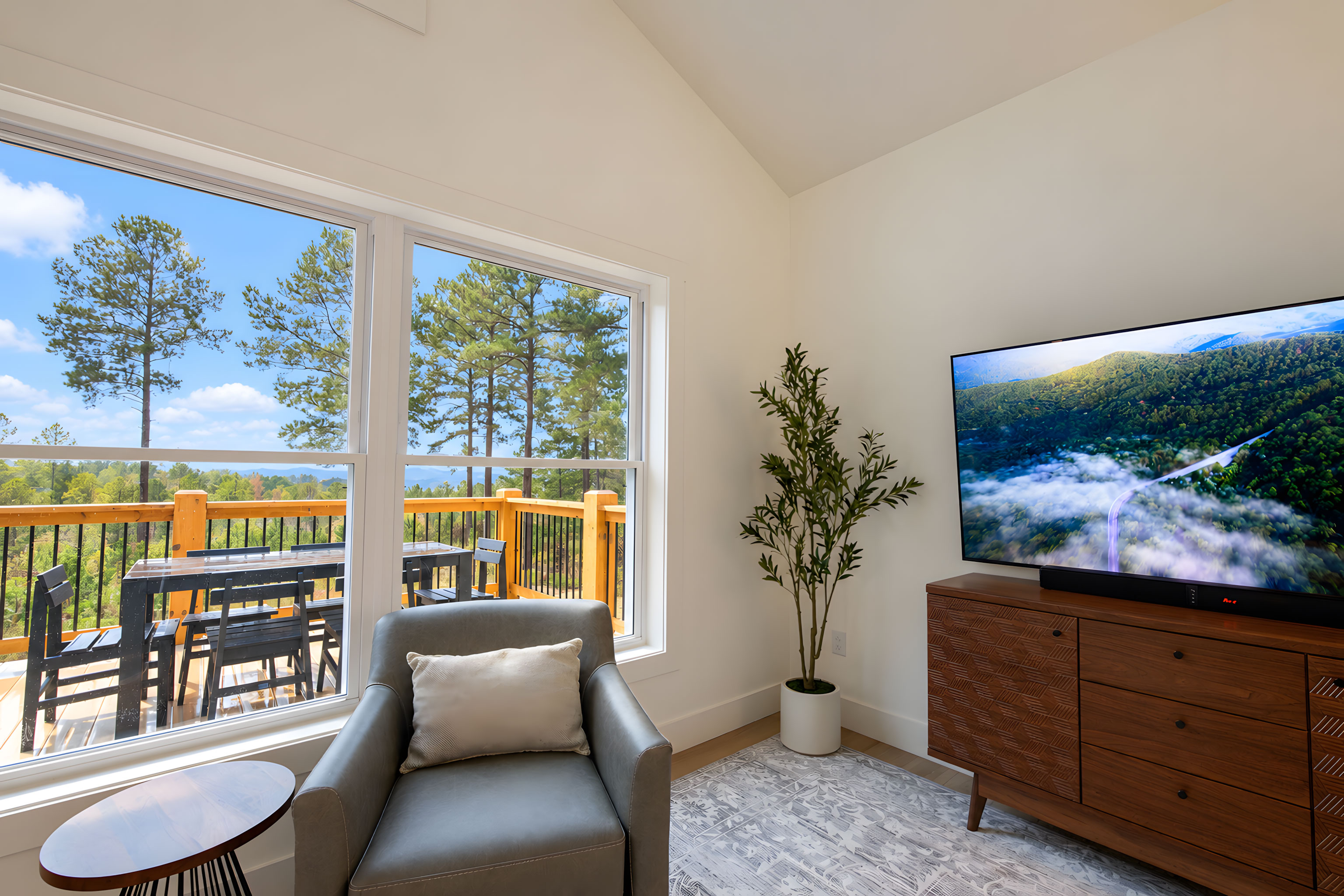 Bright living room with mountain-view windows and private dining deck