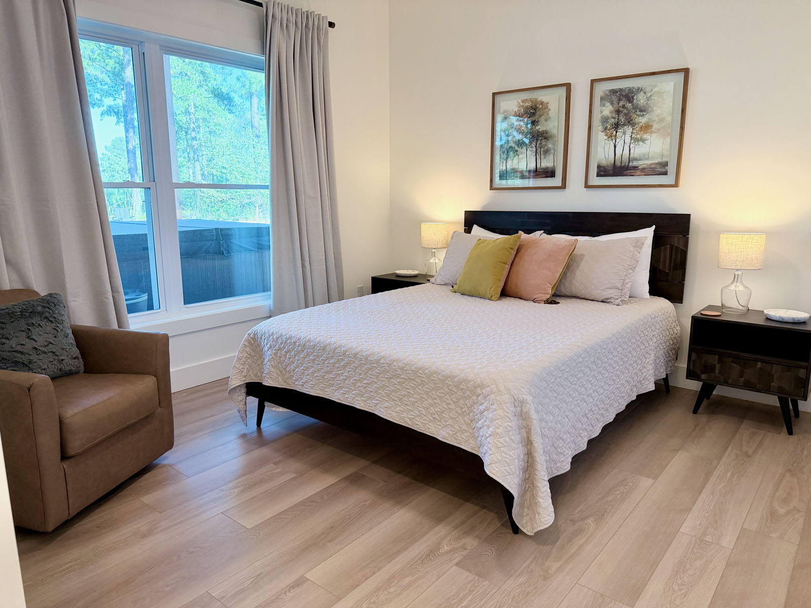 Bright, cozy bedroom with large window, forest views, and warm modern touches