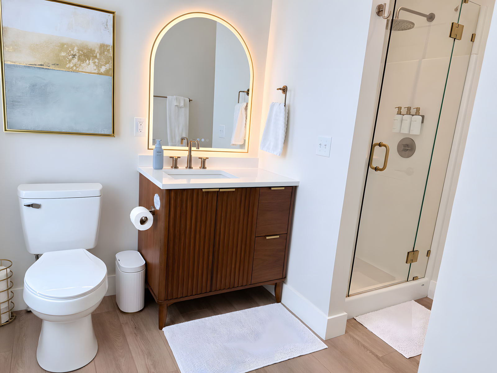 Bright spa-style bathroom with backlit mirror and glass shower