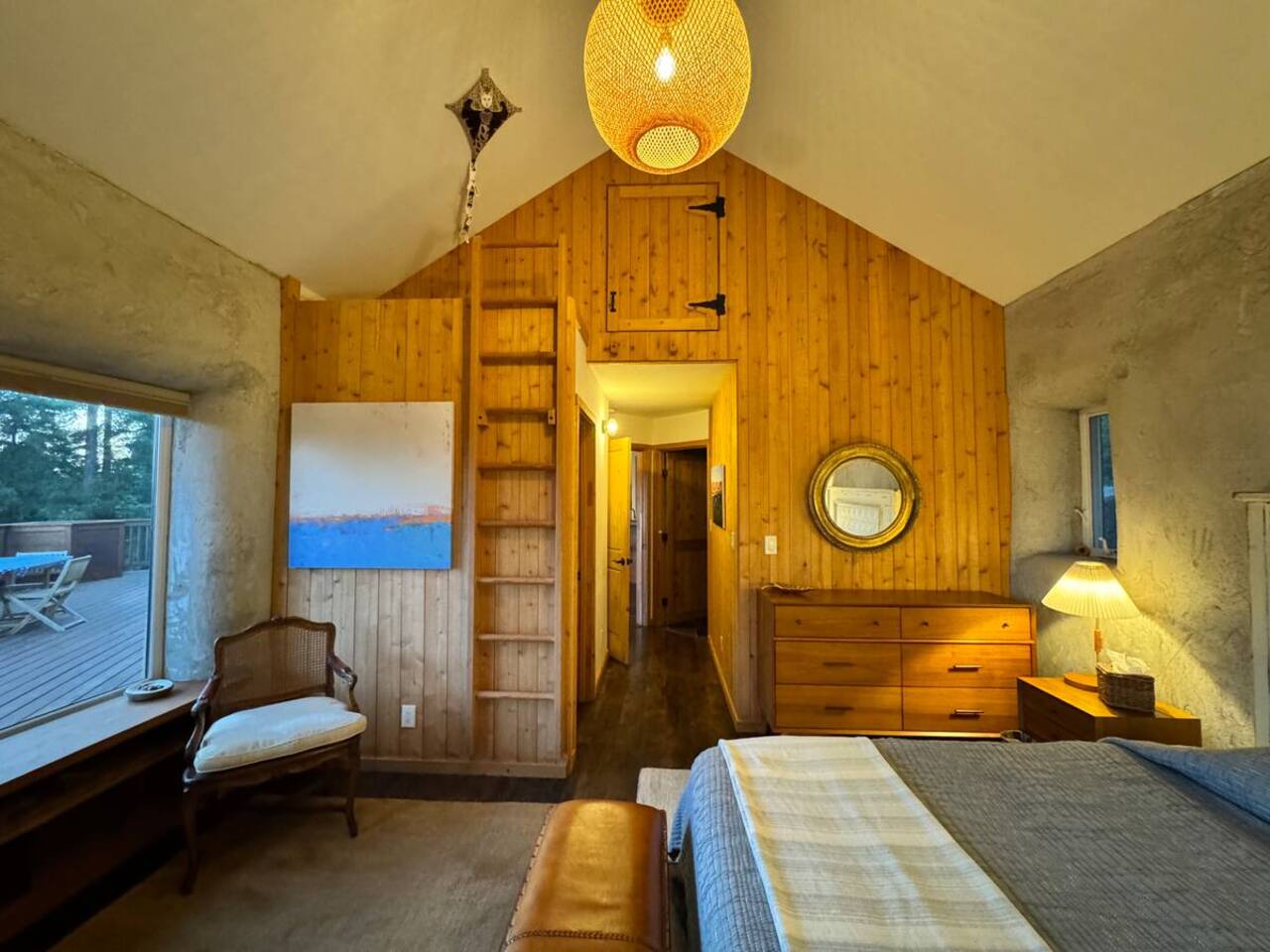 Rustic bedroom with wood-paneled ceiling for cabin charm.