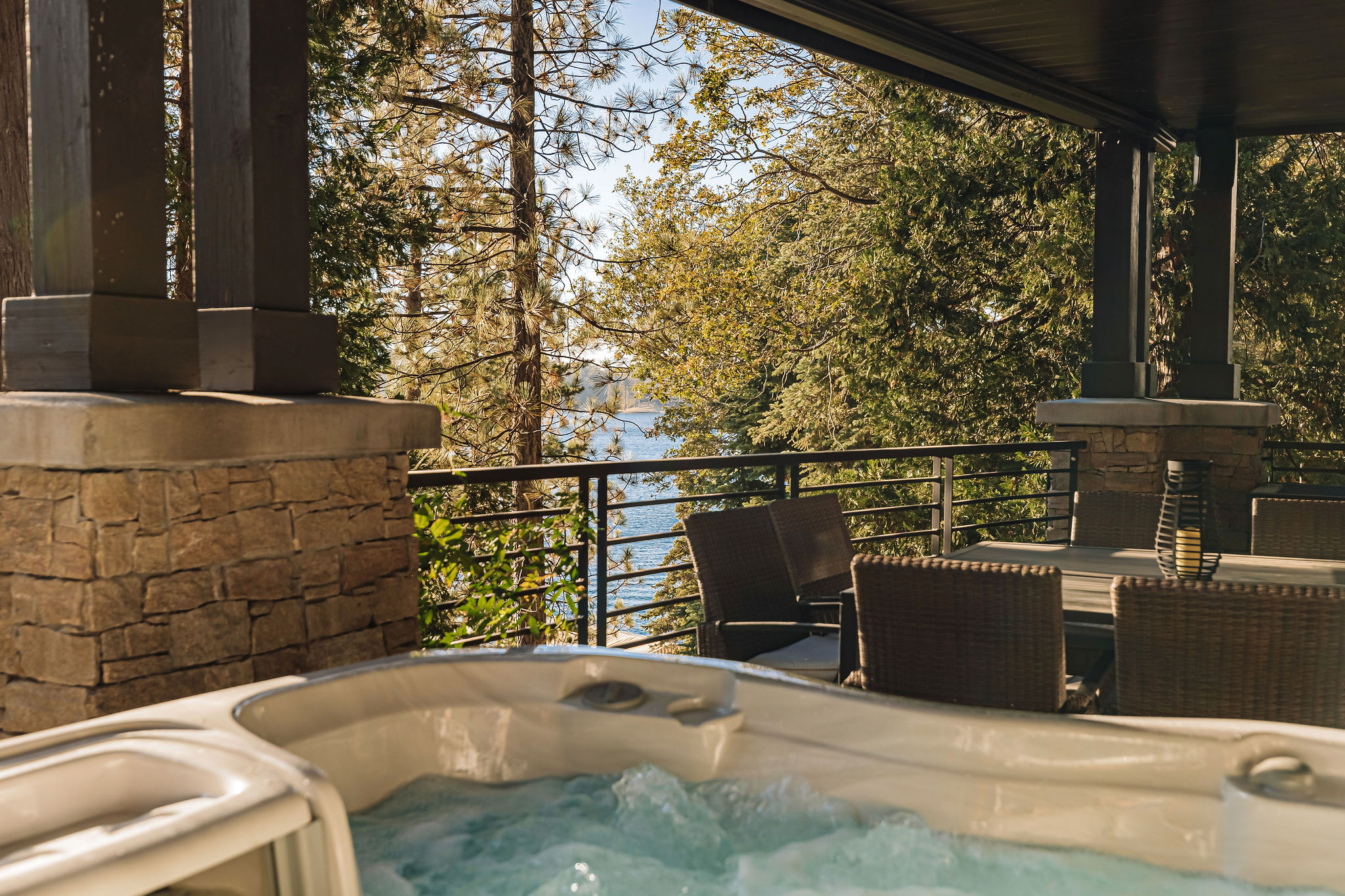 Private hot tub patio with outdoor dining and peaceful water views