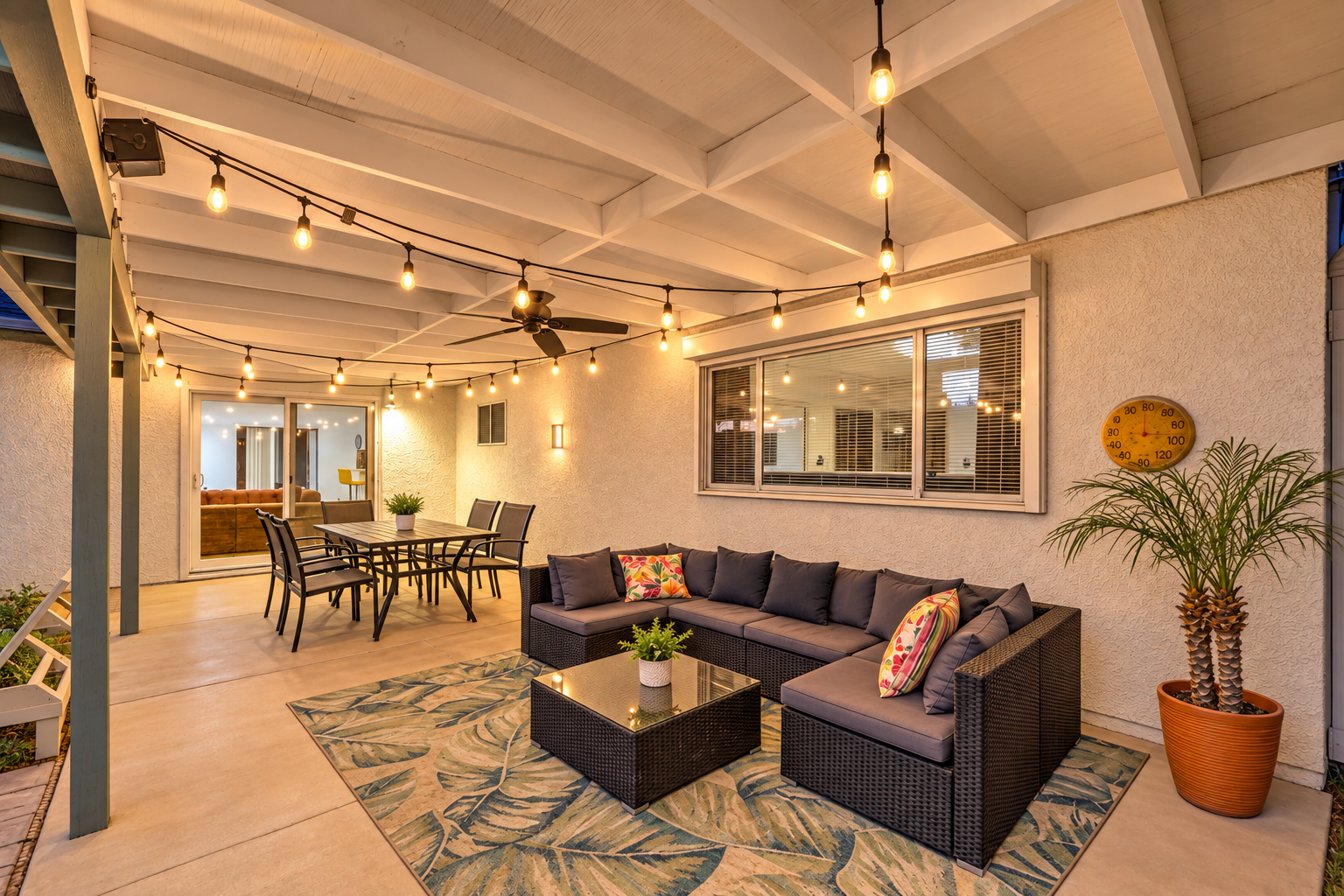 Inviting covered patio with string lights, lounge seating, and outdoor dining