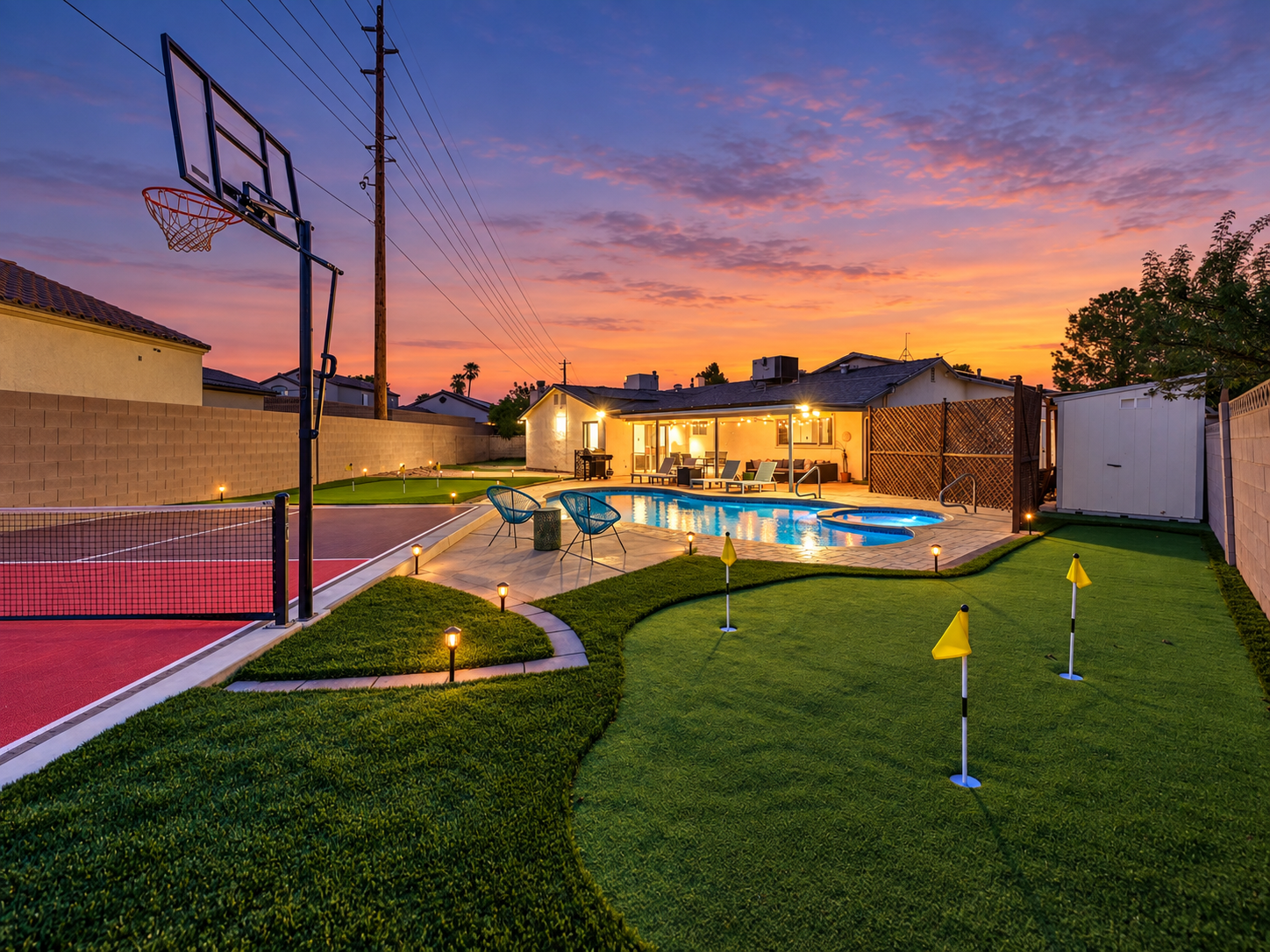 Resort-style backyard with pool, sport court & putting green at sunset