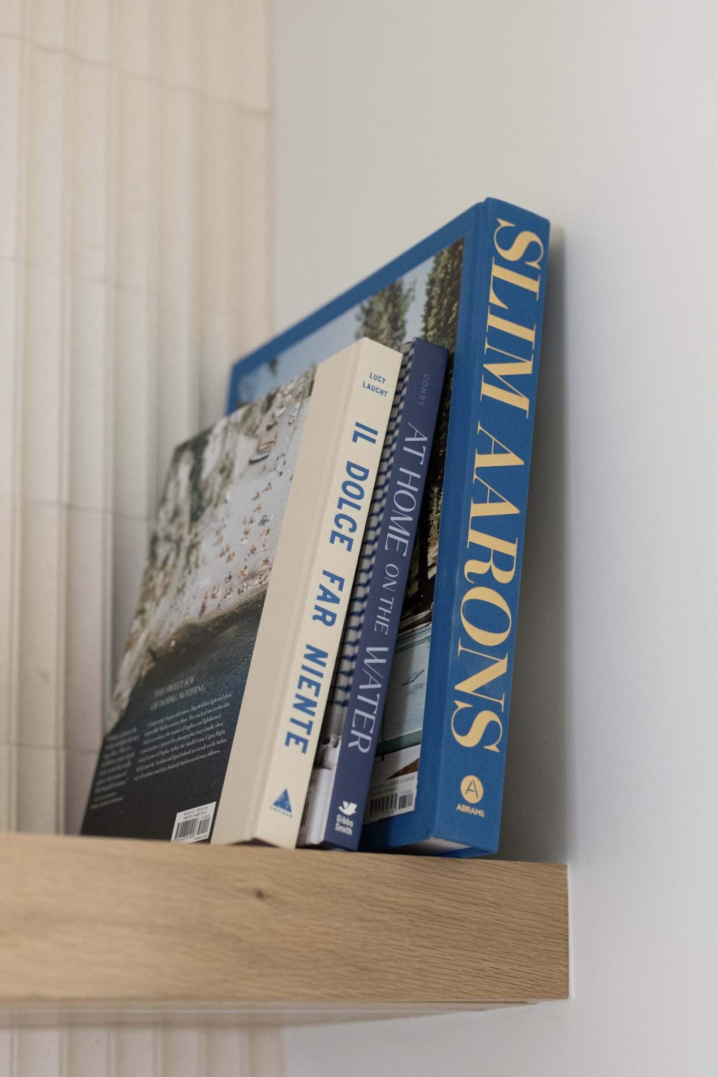 Coffee-table books on a wood shelf