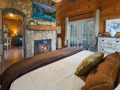 King bed with fireplace glow at Red Rose Cabin