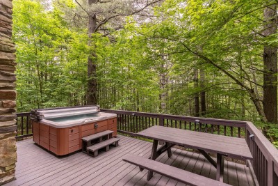 Soothe your muscles in the private hot tub nestled on the deck after mountain adventures, then savor meals at the picnic table while surrounded by peaceful forest views.