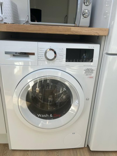 Bosch washer-dryer under counter—compact, clean, and guest-ready.