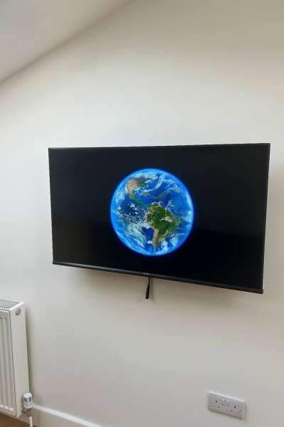 Wall-mounted TV with Earth view, minimalist setup, and clean lines.