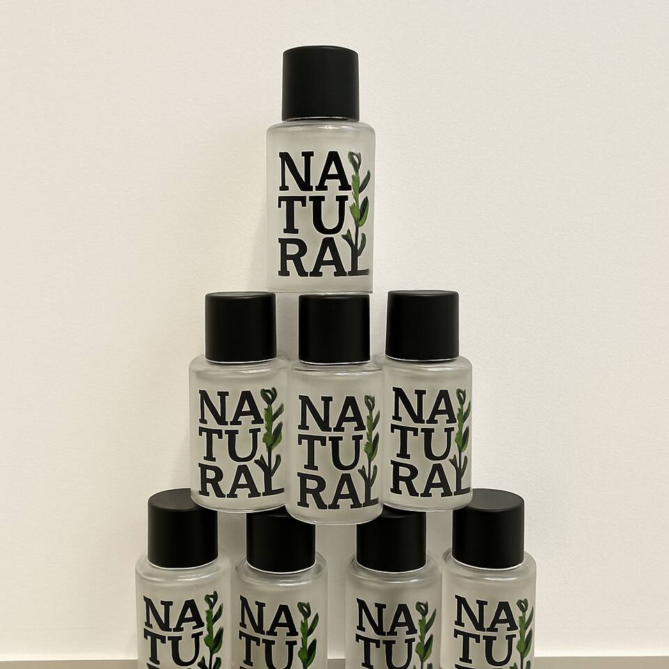 Stacked “NATURAL” bottles with clean design and leafy branding.