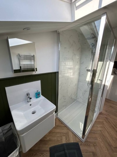 Modern bathroom with marble-tiled shower and sleek vanity setup.