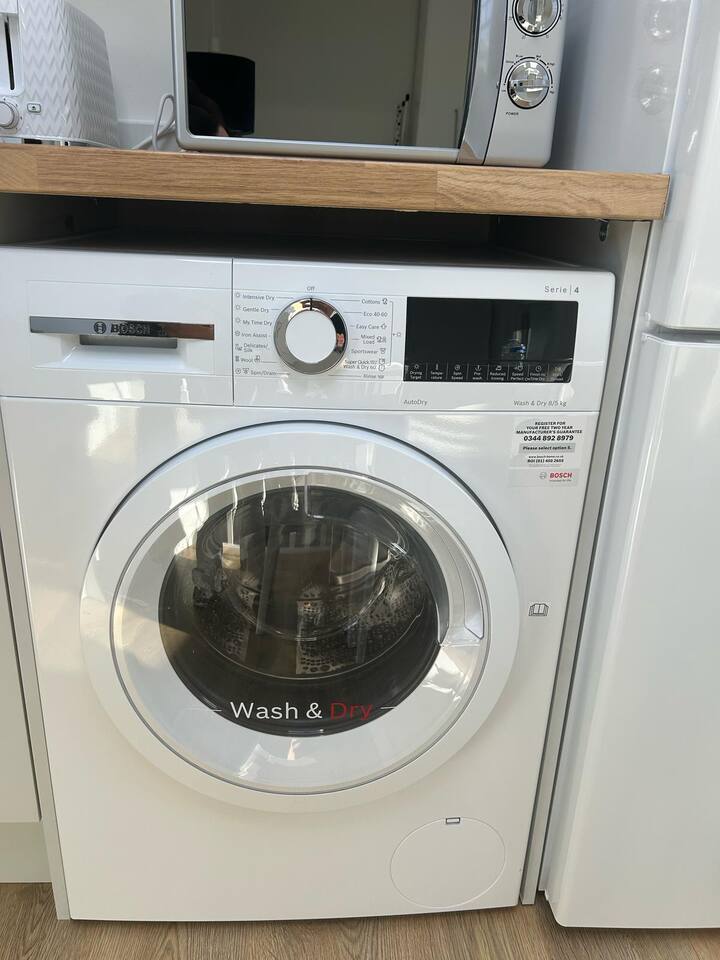 Bosch washer-dryer under counter—compact, clean, and guest-ready.