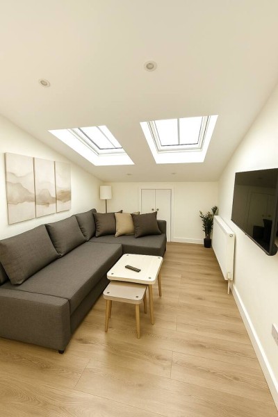 Skylit lounge with cozy sectional, soft tones, and modern TV setup.