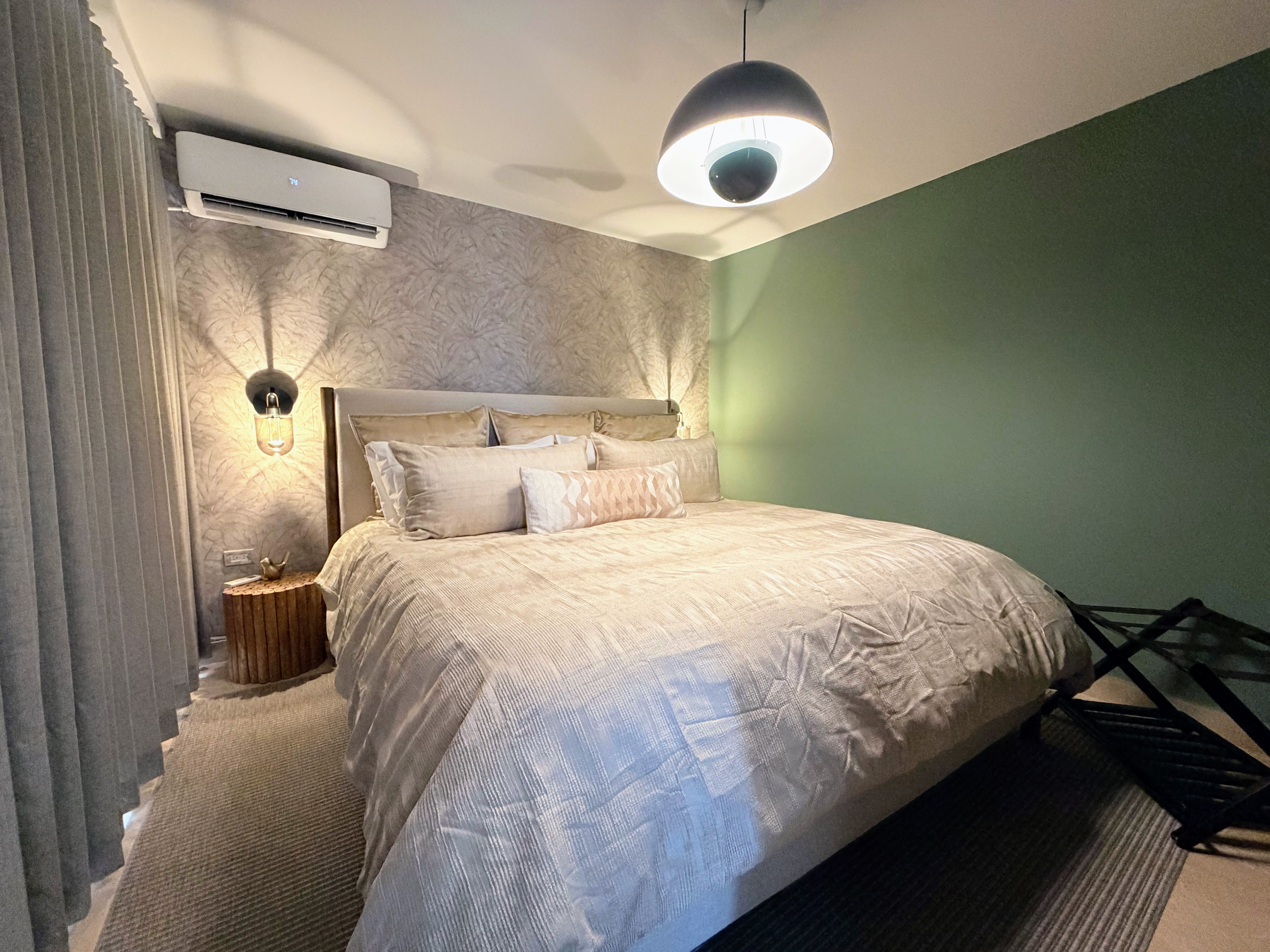 Cozy king bedroom with luxe bedding, warm lighting, and A/C comfort