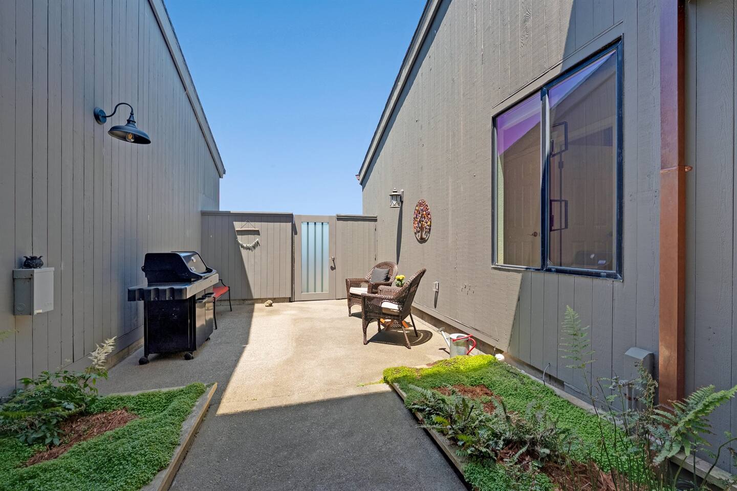 Courtyard protected from the coastal breeze, with a propane grill and seating to socialize with the cook.