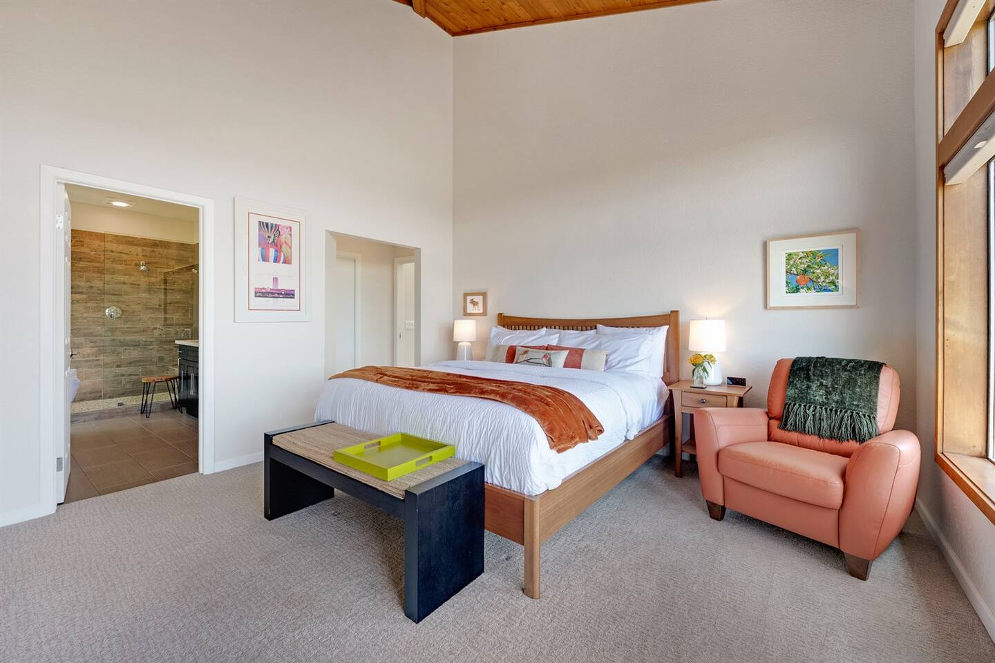 Primary bedroom with a King bed, vaulted wood ceilings, and ensuite bath.