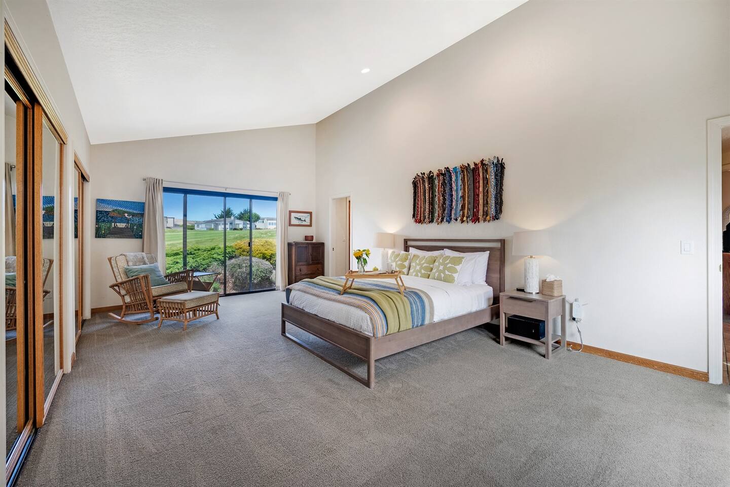 Large primary suite with sliding glass door to the back deck with a view of the 14th fairway at The Links of Bodega Harbour.