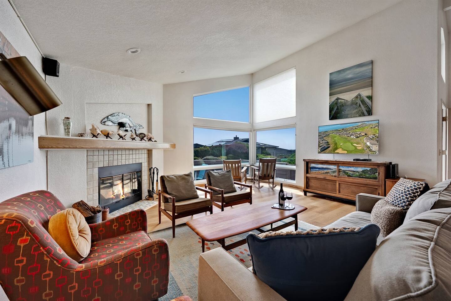 Inviting living room with a wood burning fireplace and large TV. View the sunset from the corner window.
