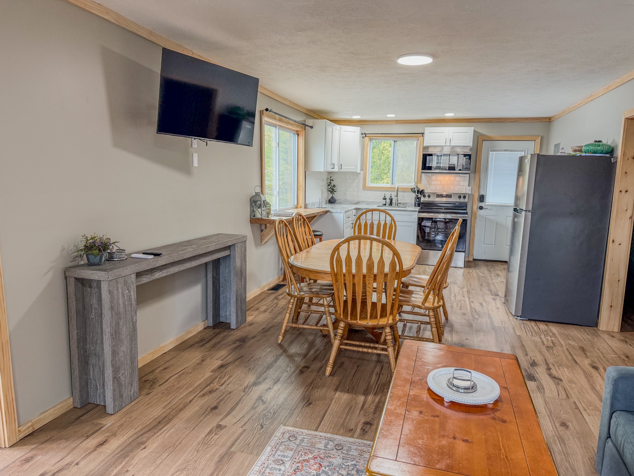 Bright open dining area with full kitchen, TV, and seating for four