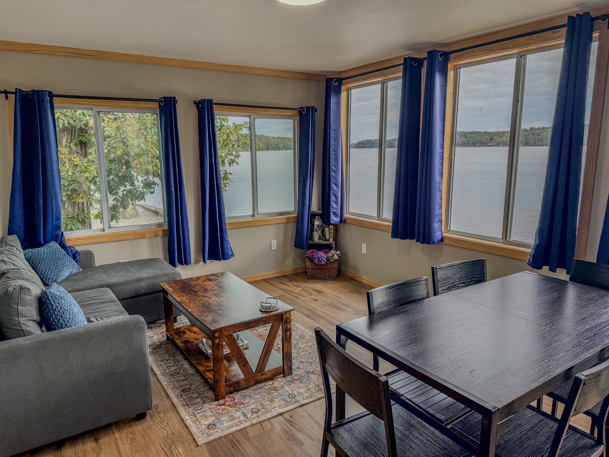 Bright lakeview living room with dining space and expansive corner windows