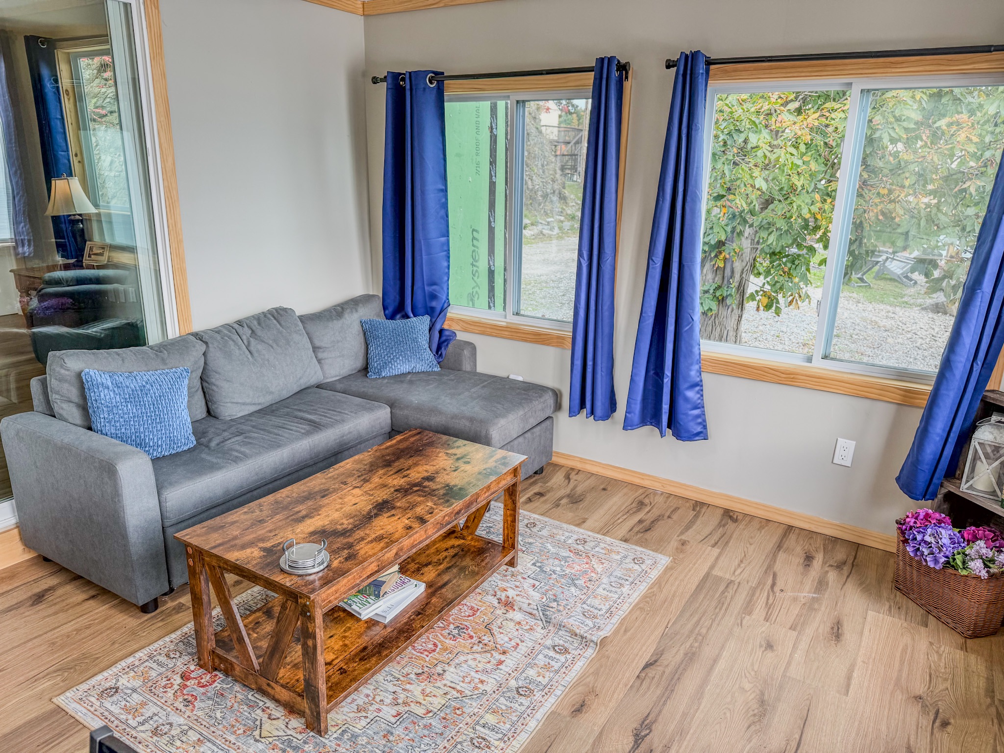 Bright, cozy living room with large windows and peaceful leafy views