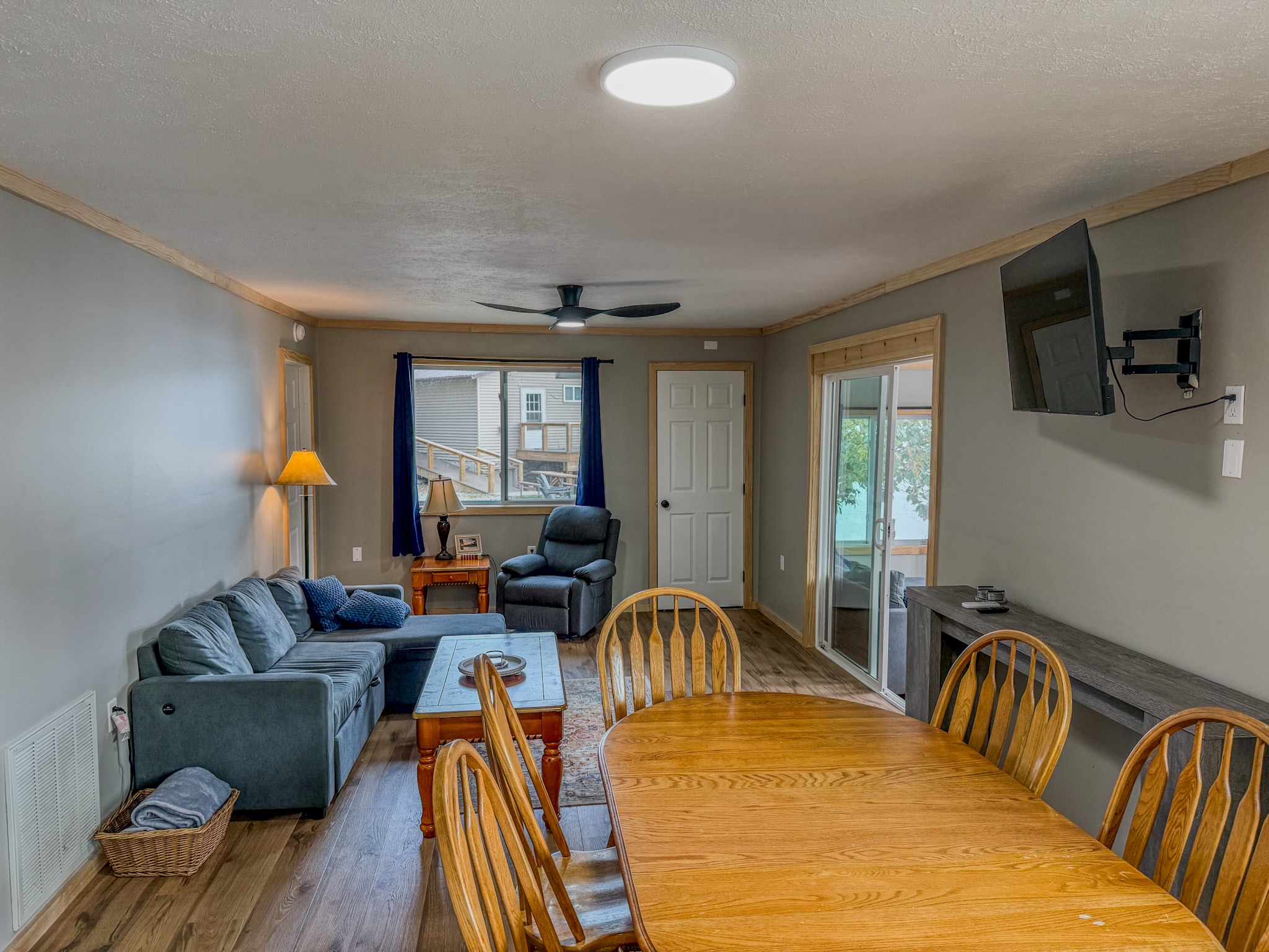 Cozy living-dining space with big table, TV, and natural light