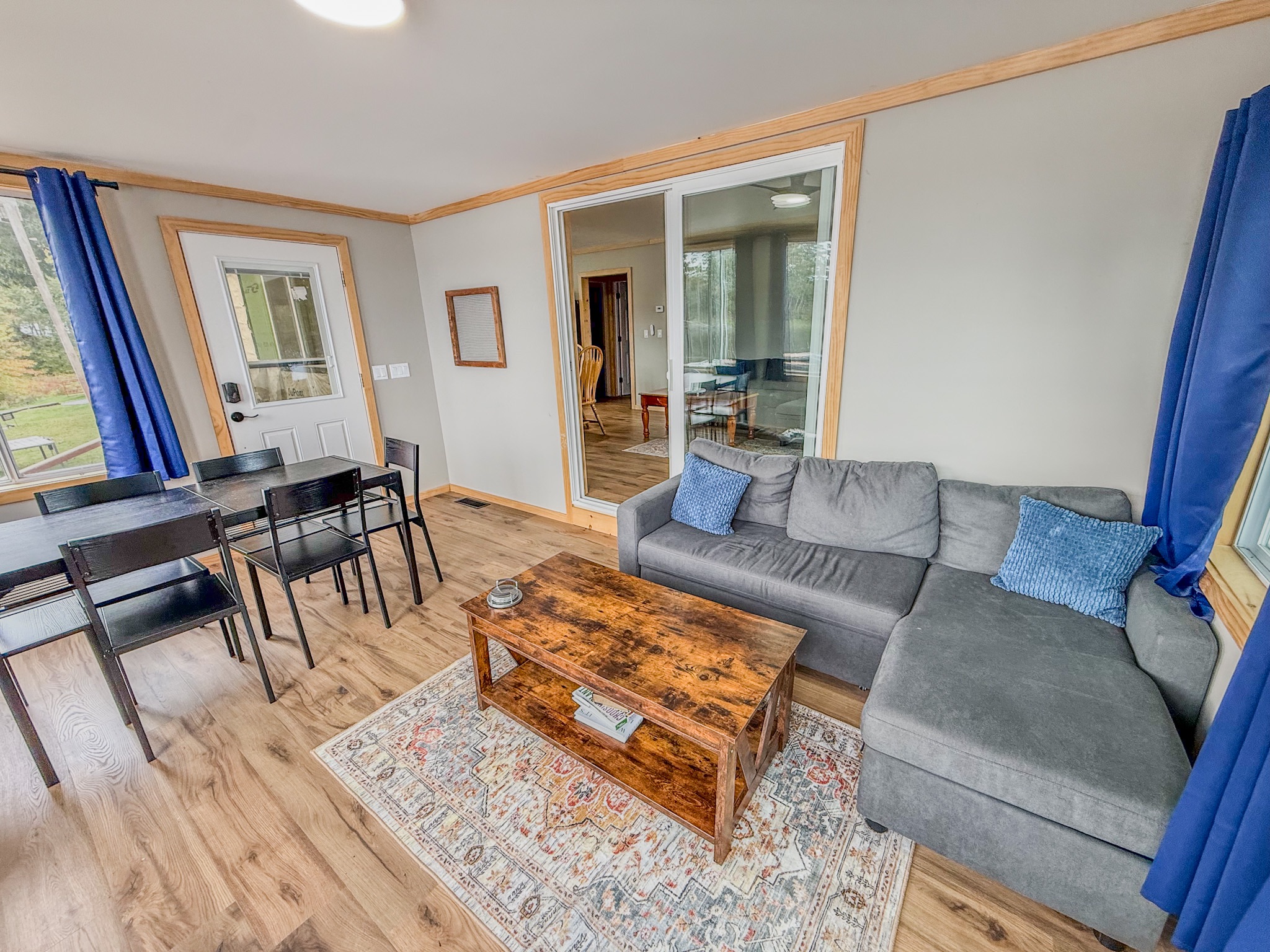Bright living area with cozy sectional, dining table, and natural light
