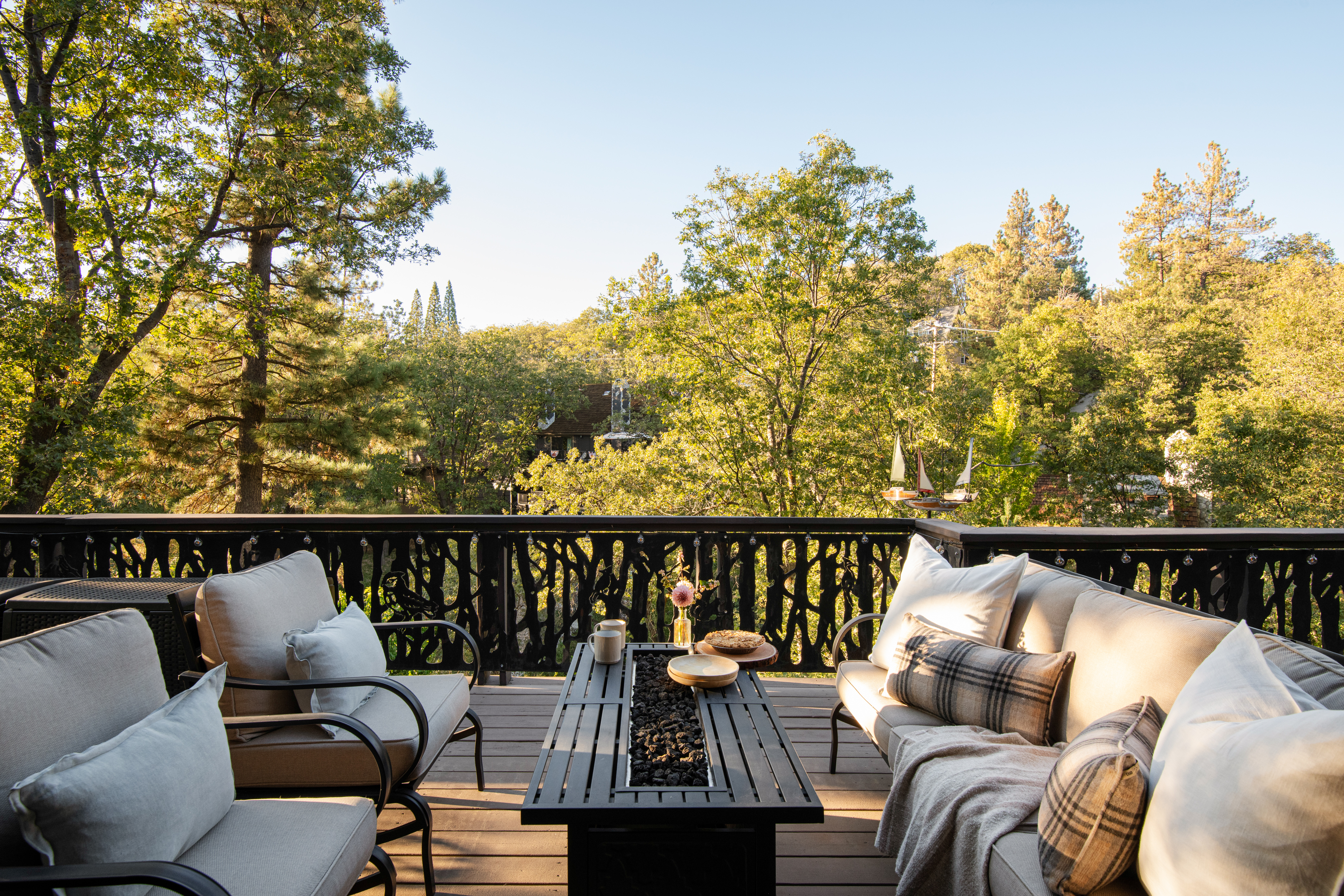 Private treetop deck with plush seating and a cozy fire table