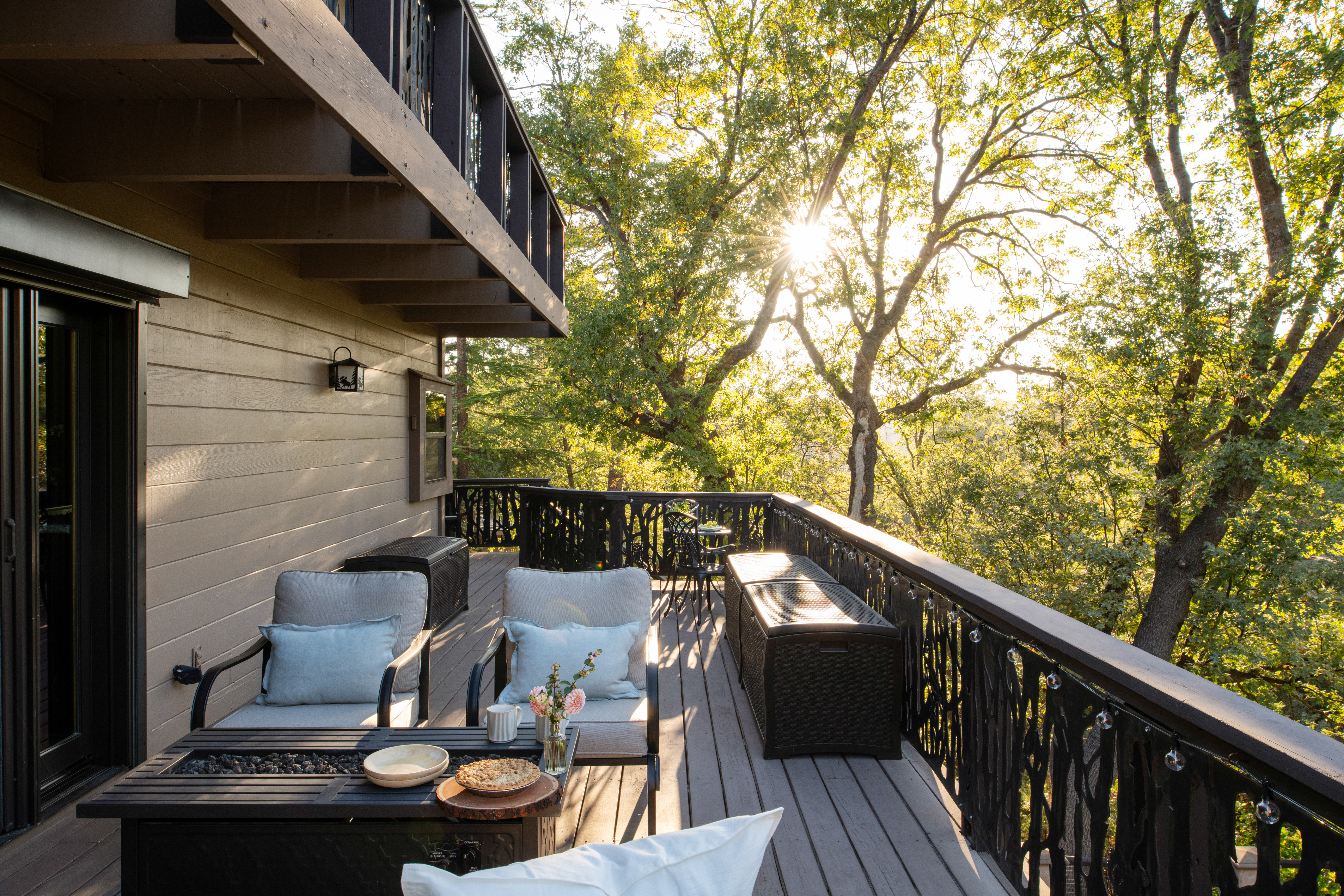 Tree-lined private deck with cozy seating and peaceful sunset glow