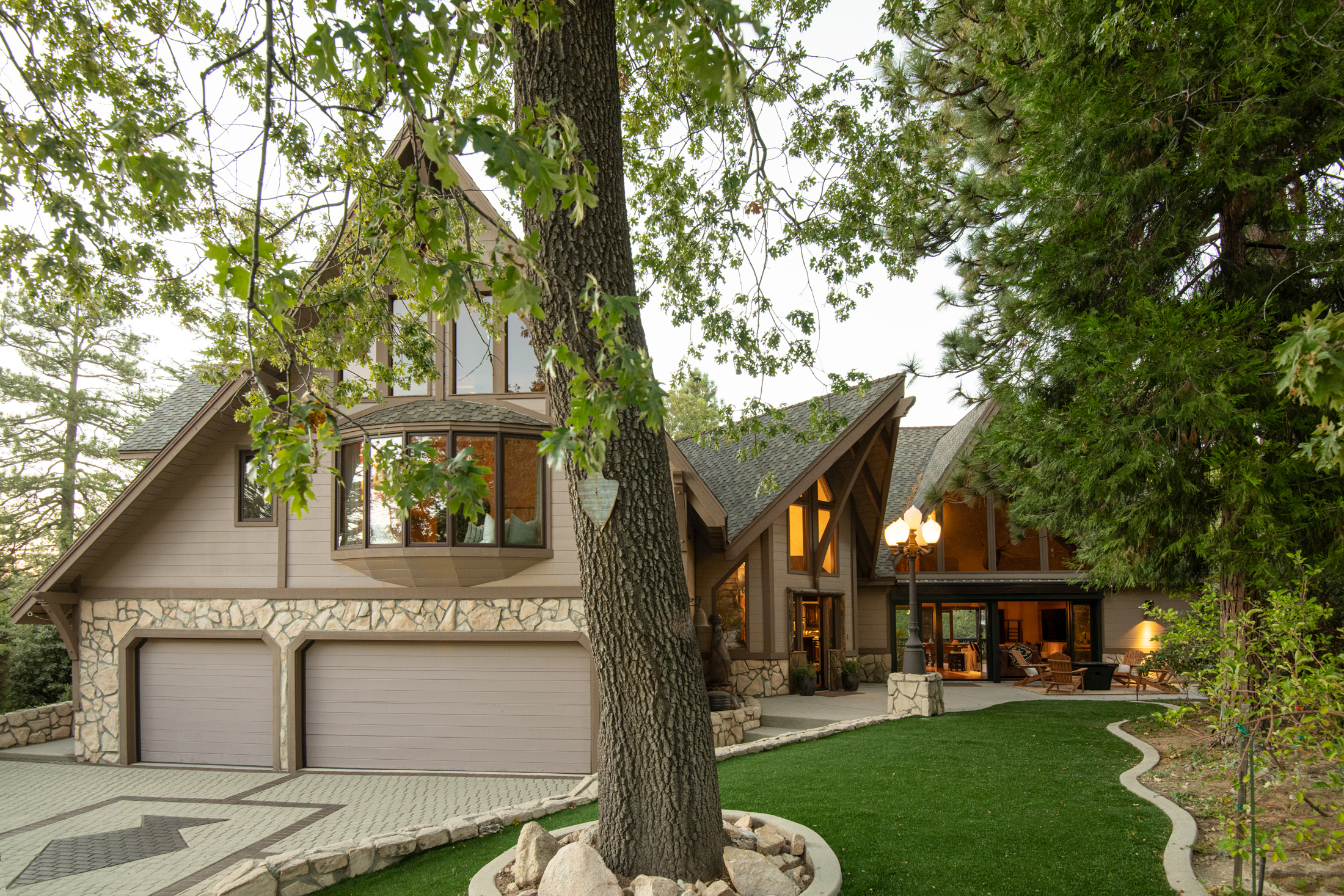 Striking mountain retreat with A-frame design, large windows, and lush grounds