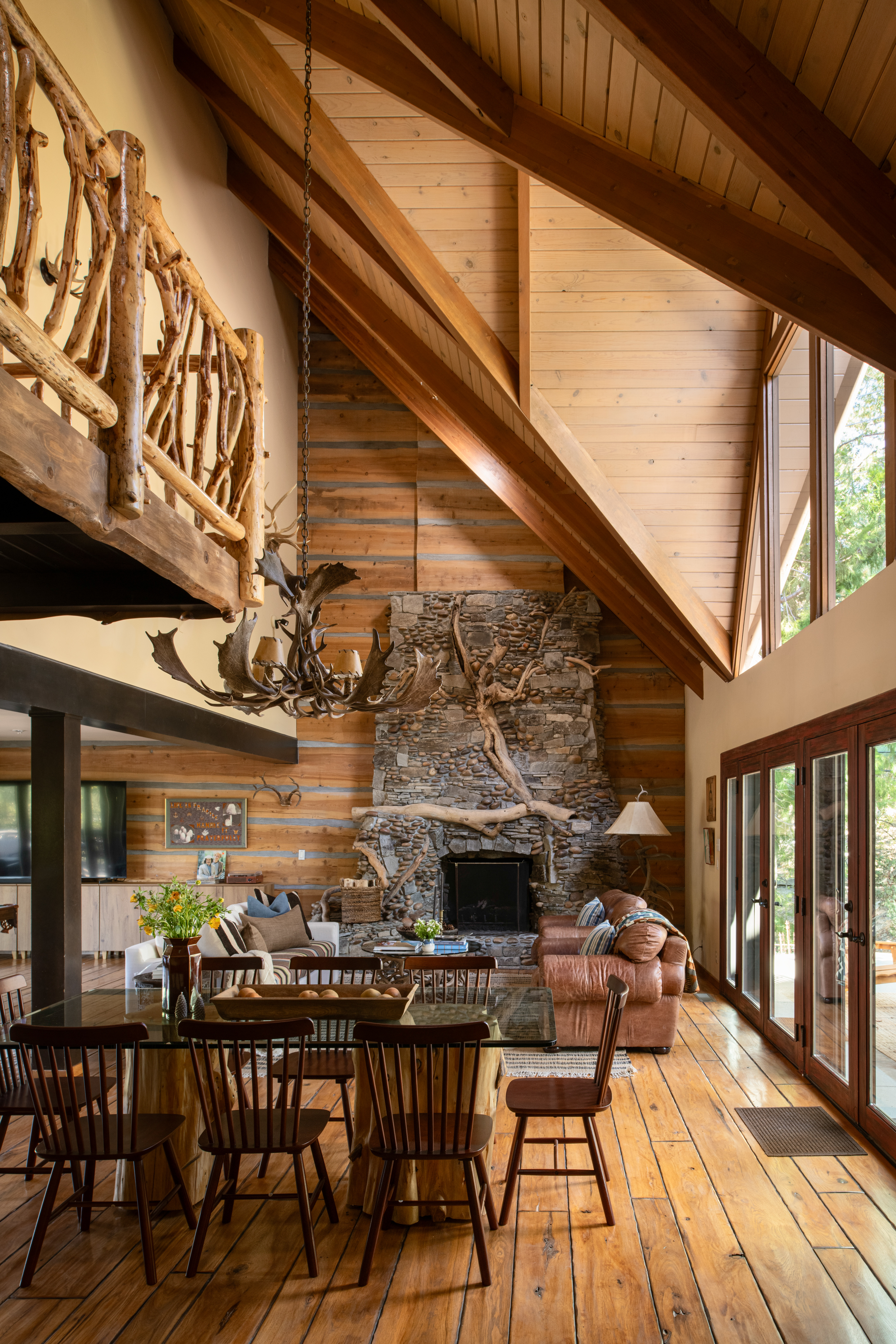 Vaulted lodge-style great room with stone fireplace and abundant light